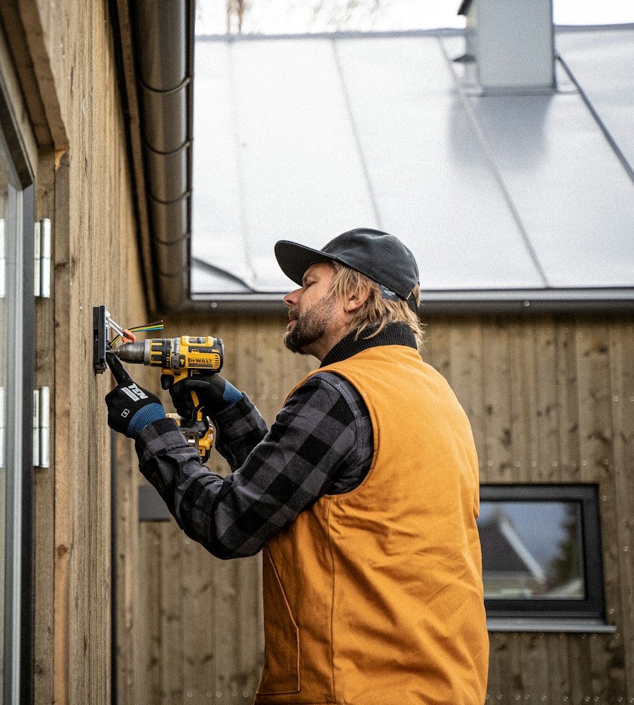 Technicien posant un équipement sur une façade Technicien posant un équipement sur une façade